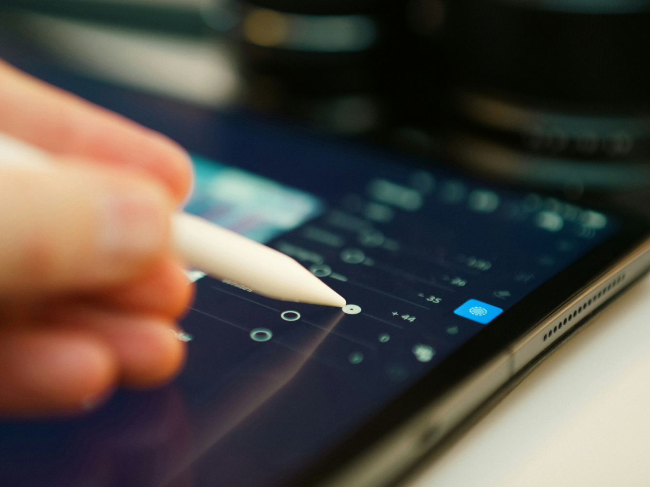 Close-up of a hand using a digital stylus on a tablet, representing the fusion of AI and creativity in modern design and innovation.